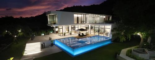 马比尼Sisid Anilao Resort的一座在晚上设有游泳池的大房子