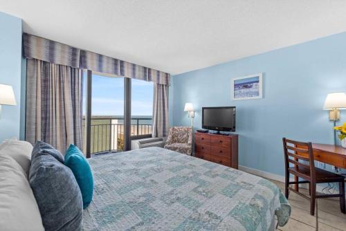 默特尔比奇Seaside Serenity Oceanview Suite w Amazing Views 604的一间卧室配有一张床、一台电视和一个阳台
