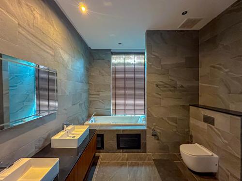 普吉镇Villa Menara Bang Tao的浴室配有两个盥洗盆和浴缸。