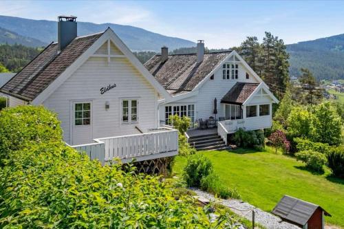 凯于庞厄尔Nydelig lite hus med egen vedfyrt baksteovn.的白色的房子,设有门廊和山地背景