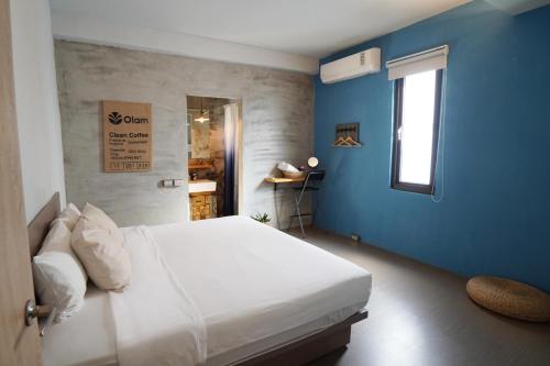 南湾山森三室墾丁包棟民宿3Rooms的卧室配有白色的床和蓝色的墙壁