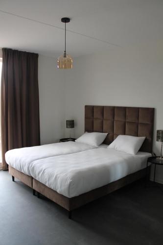 埃因霍温Trompstraat Eindhoven的一间卧室配有一张大床和大床头板