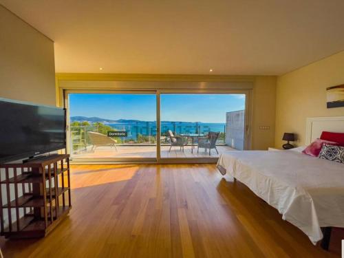 桑亨霍Villa mirador de Sanxenxo的一间卧室设有一张床和一个大型滑动玻璃门