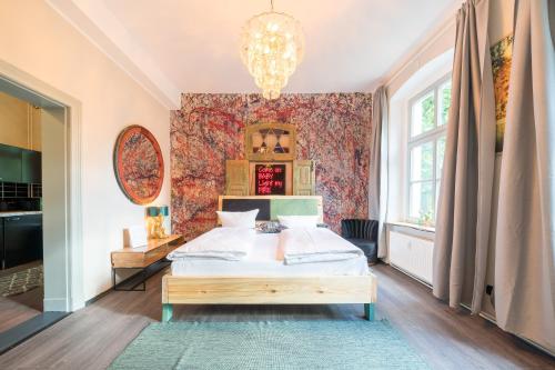 波茨坦Design Apartments - "Remise Blumberg"的一间卧室配有一张床和一个吊灯