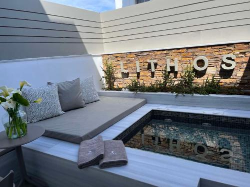 提诺斯Lithos Luxury Suites的游泳池旁带长凳的庭院