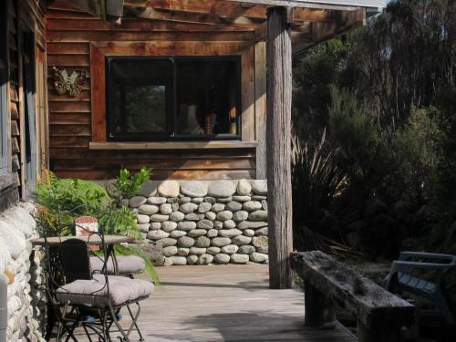 CharlestonBeaconstone Eco Stay - off grid retreat的小木屋的门廊,配有椅子和窗户