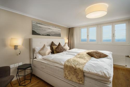 厄门玛特Boutique Hotel Moosegg的卧室配有一张带白色床单和枕头的大床。