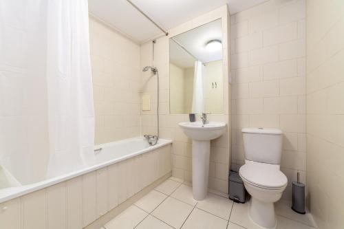 伦敦The Stratford Apartment的浴室配有卫生间、浴缸和水槽。