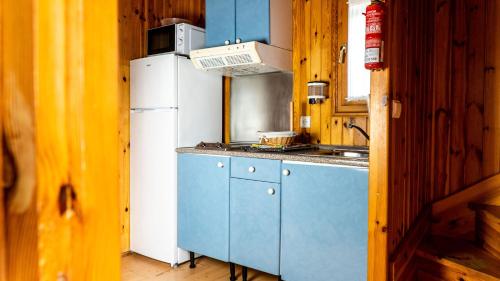 圣玛丽亚港Camping Playa Las Dunas的厨房配有蓝色橱柜和白色冰箱
