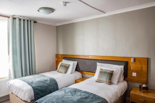 史云顿戈达德阿姆斯酒店的酒店客房设有两张床和窗户。