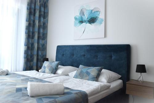尼特拉Tabáň Halifax apartment - city center & free parking的一间卧室配有一张蓝色床头板的床