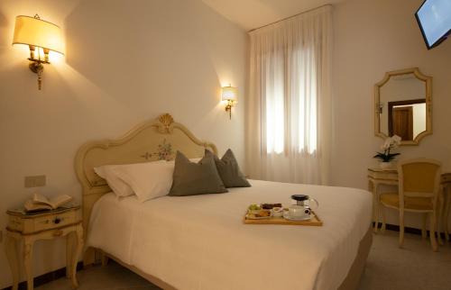 威尼斯圭里尼酒店的一间卧室配有一张床,上面放着一个食物托盘