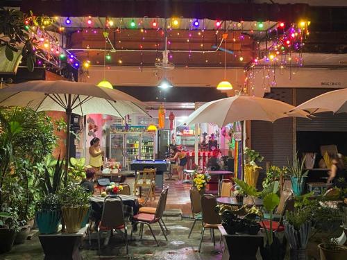 乔木提恩海滩Chai Ben guesthouse的餐厅配有两把遮阳伞和桌椅