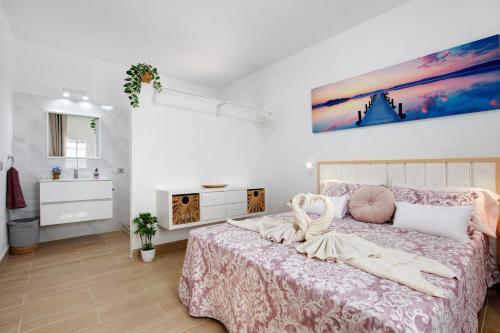 塔拉哈勒赫Apartamento El Naranjo con jacuzzi的卧室配有一张床,墙上挂有绘画作品