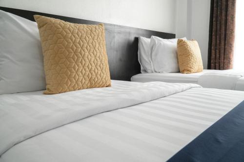 乌汶普莱梅维利知酒店的配有2张床铺的酒店客房,提供白色床单和枕头