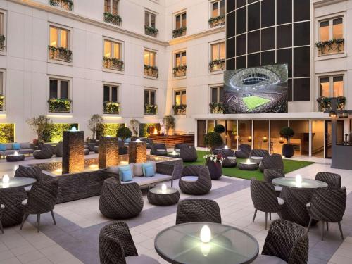 迪拜Mövenpick Hotel & Apartments Bur Dubai的酒店大堂的一张照片,里面摆放着桌椅