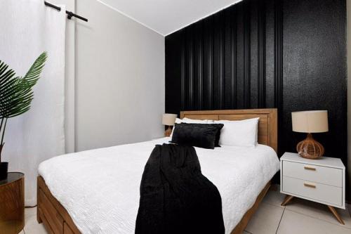 约翰内斯堡Sunrise Rivonia One Bed的一间卧室设有一张大床和黑色墙壁