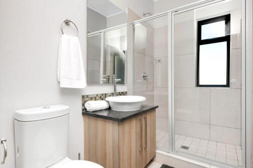 约翰内斯堡Sunrise Rivonia One Bed的白色的浴室设有水槽和淋浴。