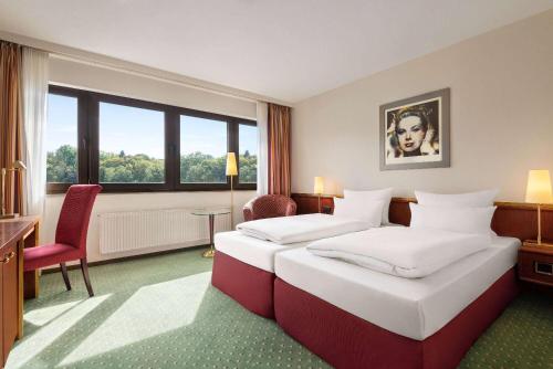 锡根Amedia Siegen, Trademark Collection by Wyndham的酒店客房设有两张床和窗户。