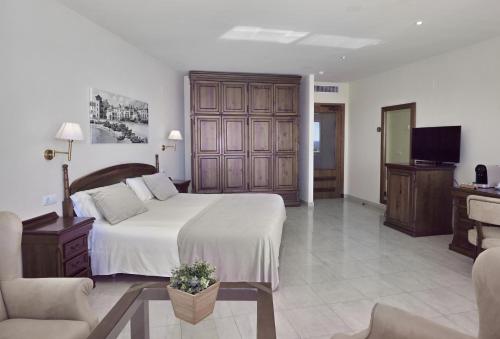锡切斯锡切斯桑威海滩高尔夫及Spa酒店的一间卧室配有一张大床和电视