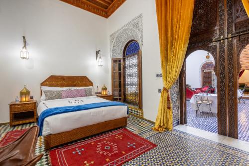 非斯Palais Nazha Fes - Luxury Lodging的一间带大床的卧室和一间带门廊的房间