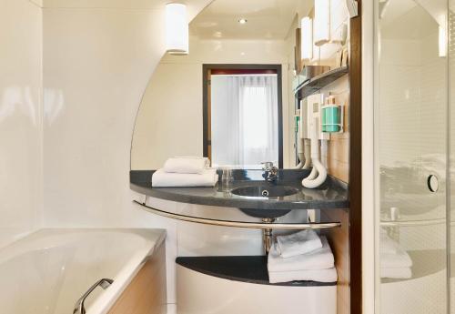 巴黎B&B HOTEL Paris Nord 18ème的一间带水槽、浴缸和镜子的浴室
