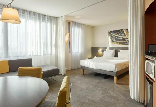 巴黎B&B HOTEL Paris Nord 18ème的酒店客房配有一张床铺和一张桌子。