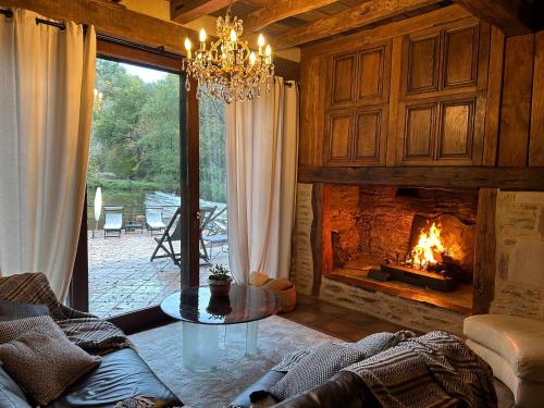 Conques-en-RouergueMoulin de Cambelong- Emilie & Thomas的客厅设有壁炉和吊灯。