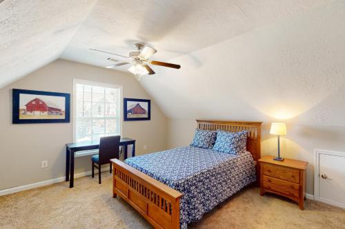 奥古斯塔Goshen Getaway的一间卧室配有一张床、一张桌子和吊扇
