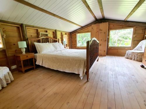 Vieux Grand PortLe Chalet, Eco Farm Stay的铺有木地板的客房内设有一间卧室和一张床。