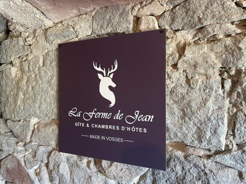 Saulxures-sur-MoselotteLa Ferme de Jean entre lacs et montagnes的石墙上的标志,上面有餐厅标志