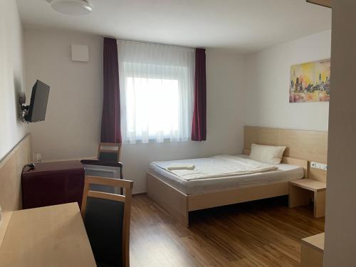 Harthofen罗比旅馆的小房间设有床和窗户