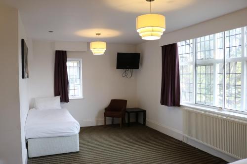 曼彻斯特Fairway Inn的客房设有1张床、1台电视和窗户。