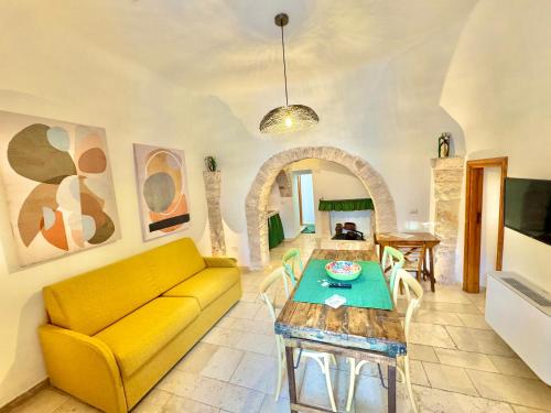 阿尔贝罗贝洛阿尔贝罗贝洛特鲁利芬尼斯度假屋的客厅配有黄色的沙发和桌子