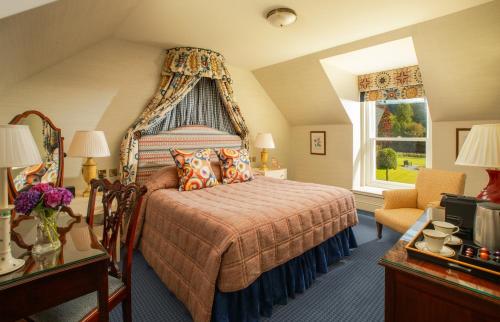 威廉堡英威尔洛奇城堡酒店的一间卧室配有一张带天蓬的床