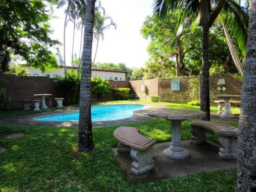 圣卢西亚Luwandla 11的后院设有桌子、长凳和游泳池