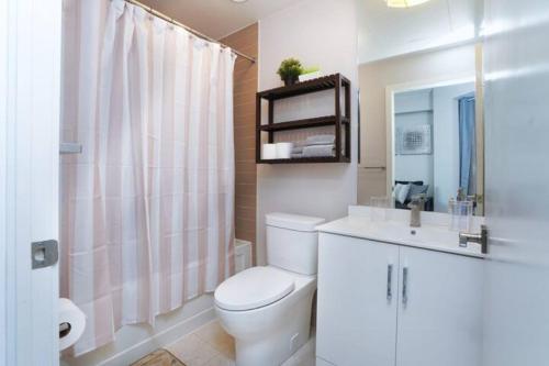 多伦多Simply Comfort Suites - One plus Den Apartment with Scotiabank Arena View的白色的浴室设有卫生间和水槽。