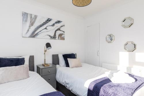 克劳利19A Apartment- Stylish & Cozy 1BR in The Heart of Crawley的卧室设有2张床和白色的墙壁。