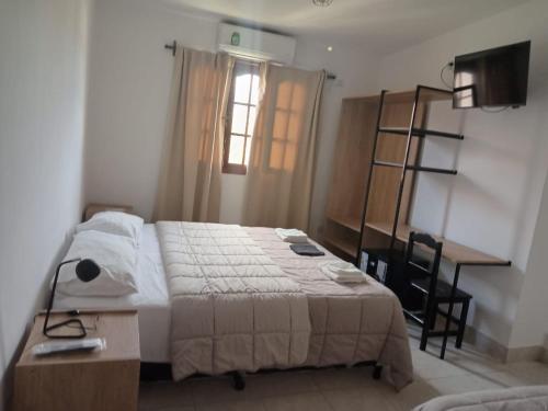 卡法亚特Cajón de Agua的一间卧室配有一张床、一张书桌和一个窗户。