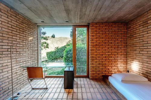 莫尔科泰Casa Brick by Quokka 360 - Luxury Design with Lake View的砖墙客房,设有一张床和一个窗户