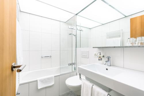 圣莫里茨Hauser Hotel St. Moritz的白色的浴室设有水槽和卫生间。