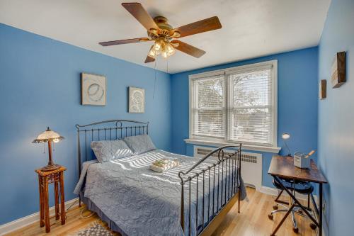LansdowneQuaint Lansdowne Getaway Near Downtown Philly!的一间卧室设有蓝色的墙壁和一张带吊扇的床。