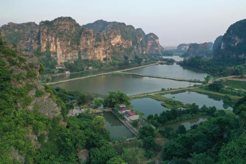 宁平Trang An Pristine View homestay的享有两座山脉之间河流的空中景致