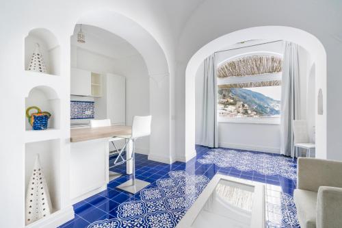 波西塔诺玛吉亚别墅的厨房铺有蓝色瓷砖地板,设有窗户。