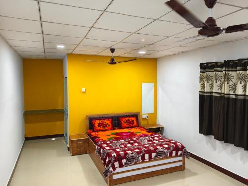 萨三吉尔Madhav Farmhouse的一间卧室配有一张黄色墙壁的床