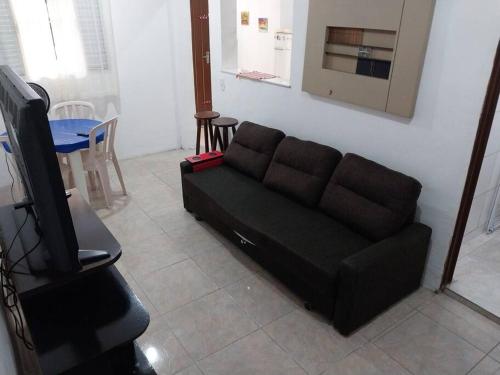 伯迪亚哥Casa a 5 minutos a pé da Praia da Enseada!的客厅配有黑色沙发和电视