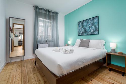 里斯本BeGuest Bright Inn Lisbon Apartment的一间卧室设有一张蓝色墙壁的大床
