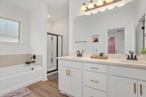 巴吞鲁日Chic Townhouse by LSU的白色的浴室设有2个盥洗盆和1个浴缸。