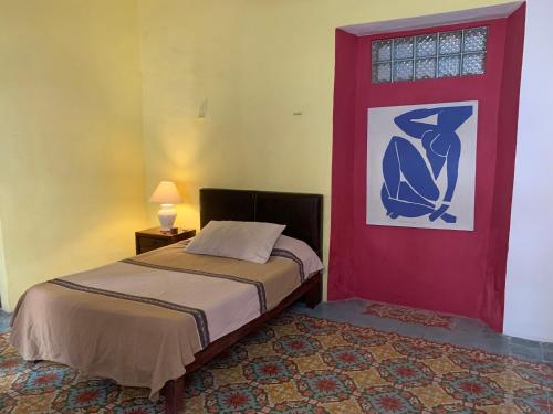 梅里达Casa "La 44"的一间卧室设有一张床和一扇红色的门