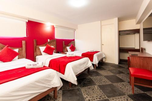 阿雷基帕斯拉尔酒店的带三张床和红色墙壁的客房